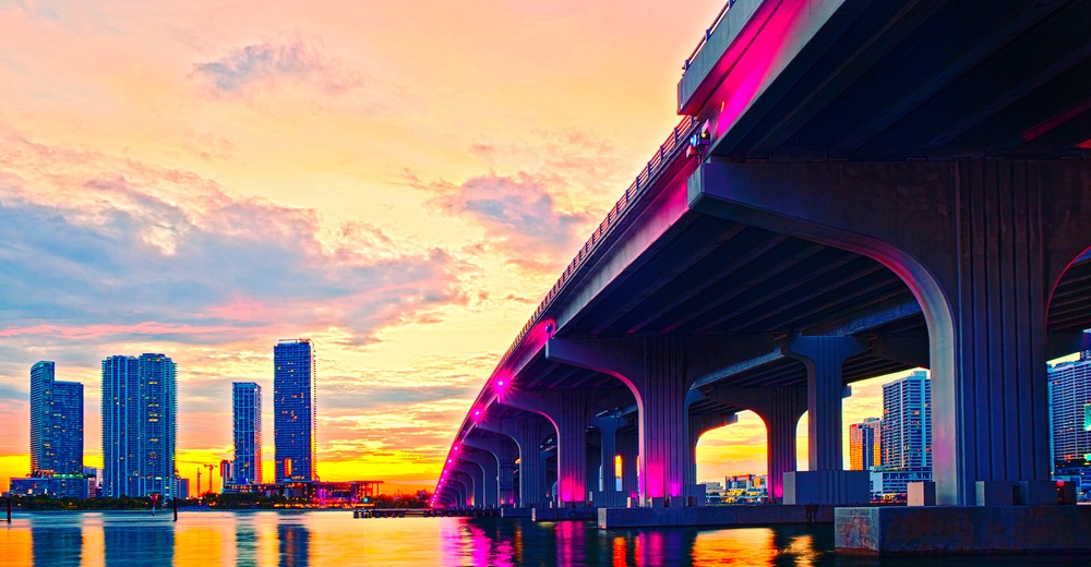 Miami Florida at sunset, colorful skyline of illuminated buildings and Macarthur causeway bridge