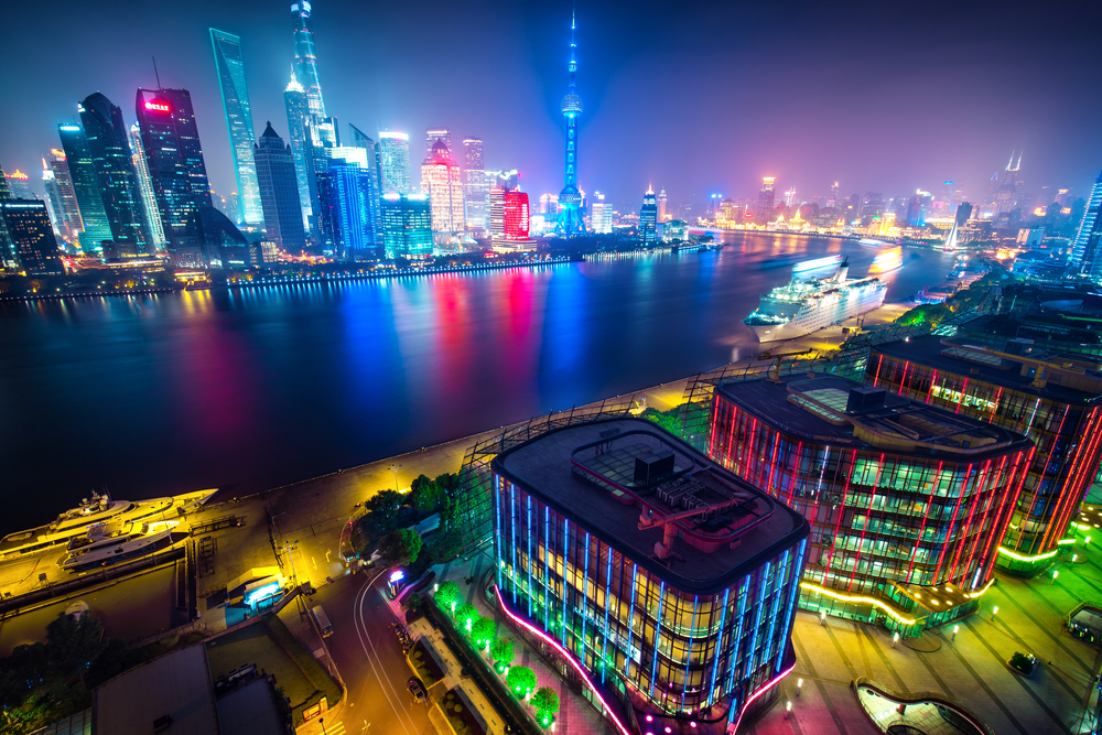 Aerial panoramic view over a big modern city by night. Shanghai, China. Nighttime skyline with illuminated skyscrapers