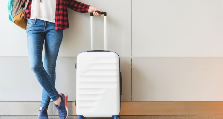 traveler posing with carry on luggage