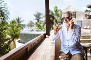 Senior man on the phone having a drink
