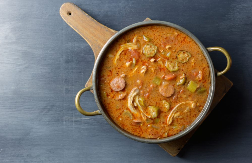 Overhead view of a pot of gumbo on a cutting board.