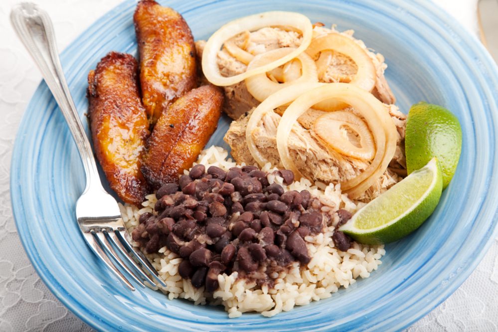 Cuban dinner, consisting of roast pork, black beans and rice, and fried sweet plantains.