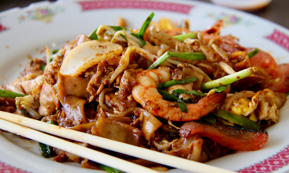 Char Kway Teow. Stir-fried rice noodles with seafood, fish cake, chinese sauce, beansprouts and chives; a highly popular street food dish in Singapore.