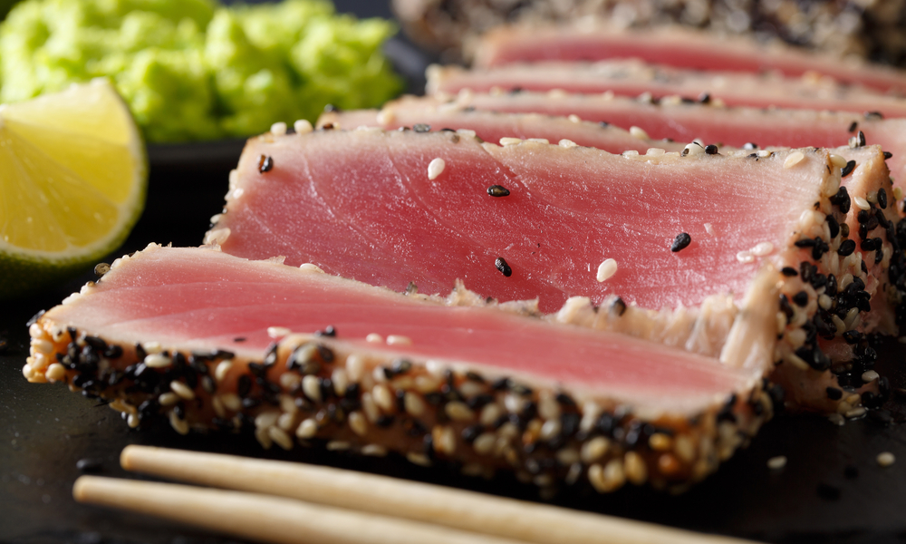 beautiful sliced tuna steak in sesame and wasabi, lime macro on the table. horizontal